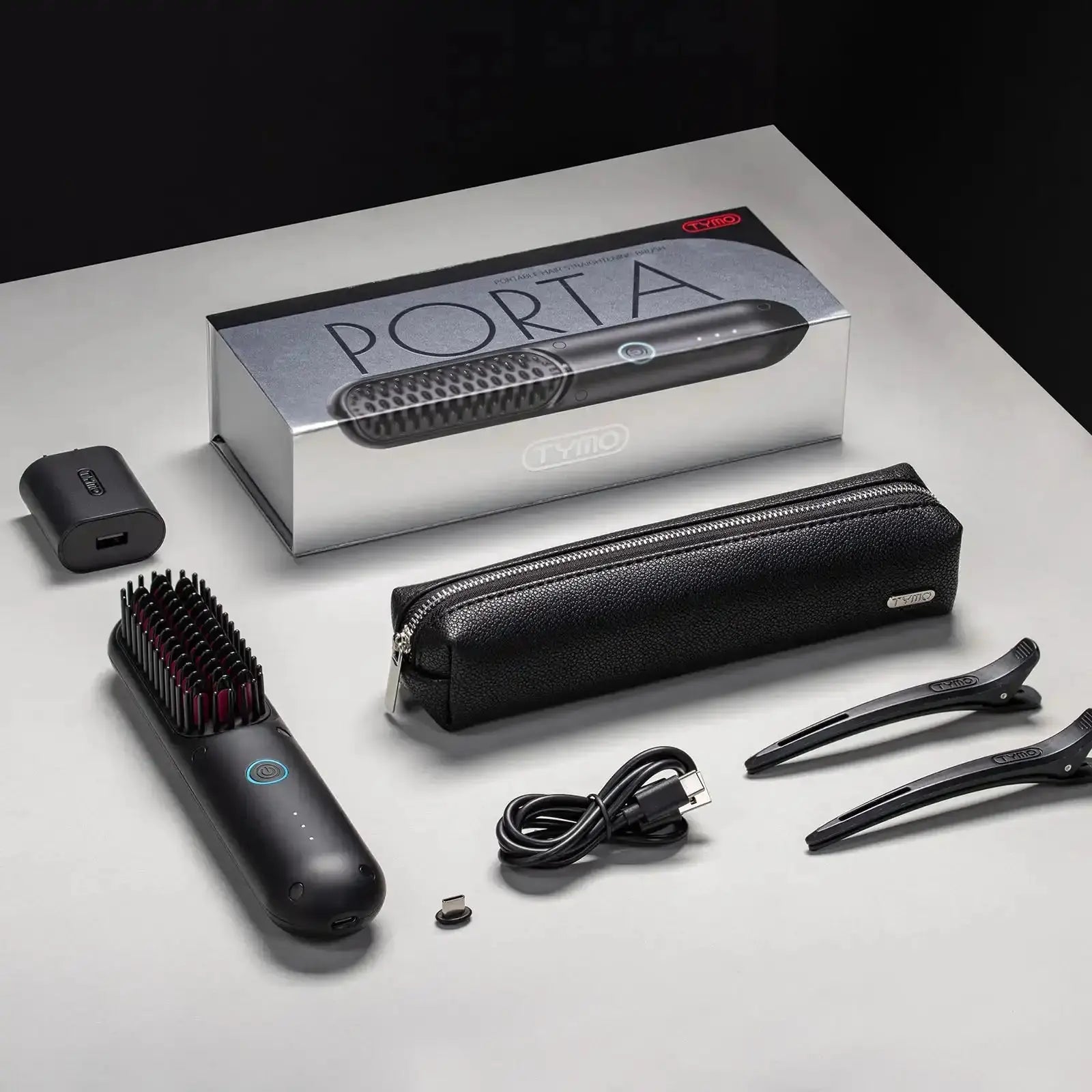 Complete packaging of TYMO PORTA cordless hair straightener with accessories including USB cable and travel pouch.
